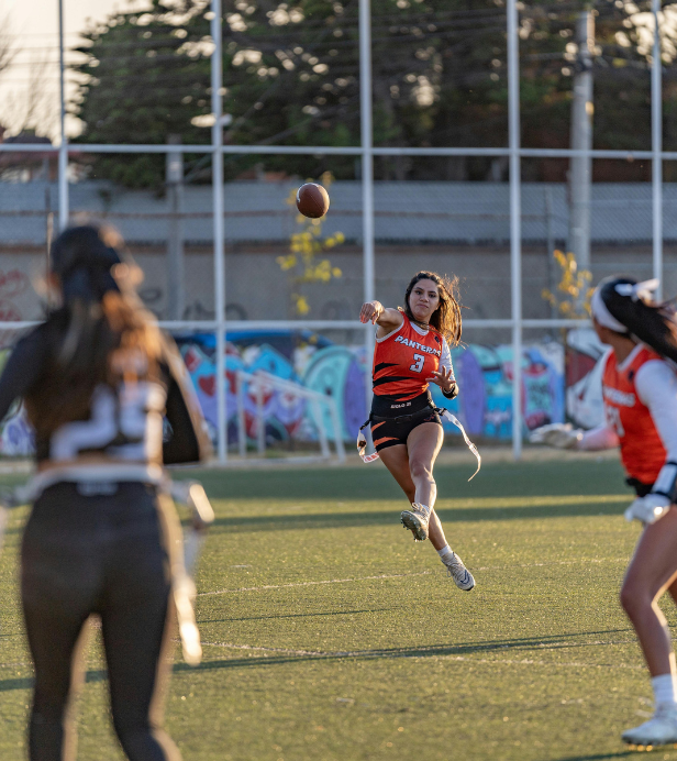 girl throwing football to a teammate
